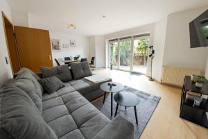 un salon avec un grand canapé et une table dans l'établissement Großzügiges Wohlfühlhaus zwischen Stadt & Meer, à Hinte