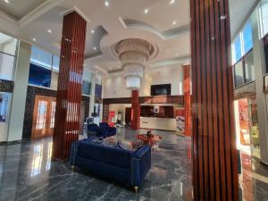 eine Lobby mit einem blauen Sofa und einem Tisch in der Unterkunft Hotel New Riviera bukavu in Bukavu