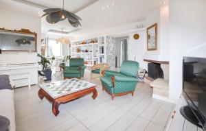 a living room with chairs and a table and a fireplace at 3 Bedroom Stunning Home In Talasani in Talasani