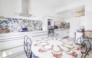 a white kitchen with a table and chairs at 3 Bedroom Stunning Home In Talasani in Talasani