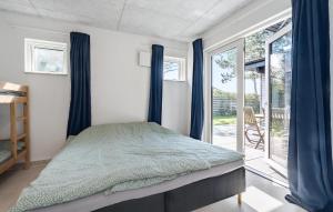 a bedroom with a bed with blue curtains and a window at 3 Bedroom Lovely Home In Martofte in Martofte +15 photos