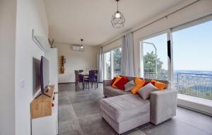 a living room with a couch and a large window at Splendida Casa In Corsanico in Massarosa