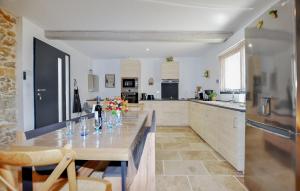 una cucina con tavolo e vasetti di fiori di 4 Bedroom Gorgeous Home In Tournissan a Tournissan
