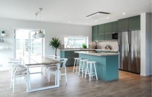 a kitchen with green cabinets and a table and chairs at 4 Bedroom Cozy Home In Ystad in Ystad