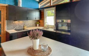 a kitchen with a vase of flowers on a table at 5 Bedroom Cozy Home In Hebnes in Hebnes