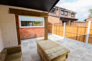 a porch with a wooden bench on a balcony at 'Station House' Cosy Renovated Family-Friendly Home in Runcorn, Cheshire - Train Station Liverpool Chester Links, Brindley Theatre in Runcorn