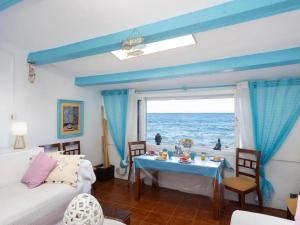 un soggiorno con un tavolo e una finestra con vista sull'oceano di Casa en el mar a Candelaria