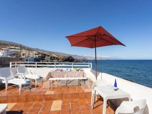 un patio con tavolo, sedie e ombrellone di Casa en el mar a Candelaria