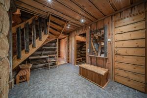 Zimmer mit Holzwänden und einer Treppe in einer Hütte in der Unterkunft Wellamo by Aavalevi in Levi