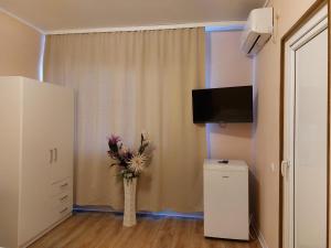 a room with a vase with flowers in it at Vila La Famiglia in Eforie Nord