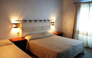 a hotel room with two beds and a window at B&B Sa Soliana in Telti