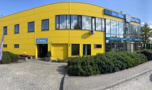 a yellow building with a sign on the side of it at Avēnija in Aizkraukle