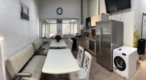 a kitchen with a white table and a refrigerator at Avēnija in Aizkraukle