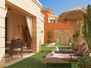 an outdoor patio with chairs and a swimming pool at Royal Garden Villas, Luxury Hotel in Adeje