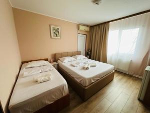 a hotel room with two beds and a window at Vila La Famiglia in Eforie Nord