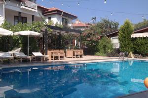 a swimming pool with chairs and umbrellas next to a house at B&B Boutique Hotel in Dalyan