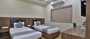 Postel nebo postele na pokoji v ubytování Hotel Limra Vadodara