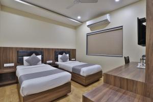 Postel nebo postele na pokoji v ubytování Hotel Limra Vadodara