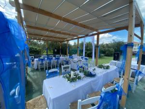 Una carpa con mesas y sillas blancas y sillas azules. en Brunswick Villa Units Party & Wedding Complex by "elite", en Laganas
