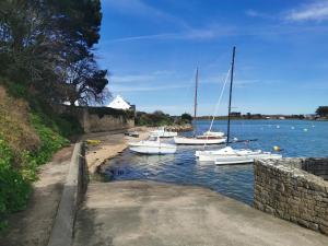 a group of boats are docked in the water at La maison Kerserho in Plouhinec