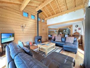 a living room with a leather couch and a fireplace at CH136 - Chalet Kimberley Centre village les Carroz in Les Carroz d'Araches