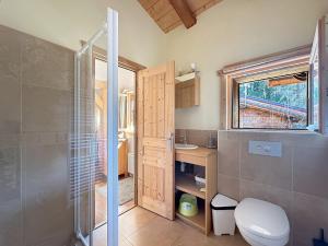 a bathroom with a toilet and a glass shower at CH136 - Chalet Kimberley Centre village les Carroz in Les Carroz d'Araches +8 photos