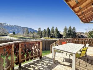 a wooden deck with a table and a chair on it at CH136 - Chalet Kimberley Centre village les Carroz in Les Carroz d'Araches