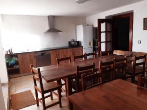 cocina con mesa de madera y sillas de madera en Habitación Tomillar, en Lumpiaque