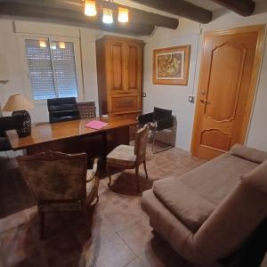 Una sala de estar con una mesa de madera y un sofá. en Habitación Tomillar, en Lumpiaque