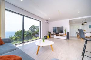 a living room with a couch and a table at Villa Deavista by Villsy in Matulji