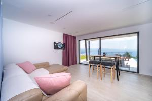 a living room with a couch and a table with chairs at Villa Deavista by Villsy in Matulji
