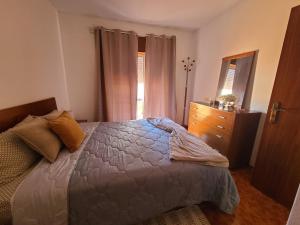 Un dormitorio con una cama, una cómoda y ventanas. en Chez Marlene, en Lagos