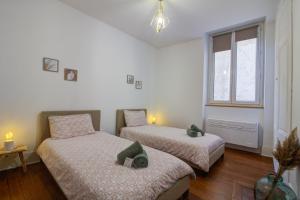 una camera da letto con due letti e una finestra di chez lulu-La salle de jeux-3 chambres-5pers-cnpe bugey a Ambérieu-en-Bugey
