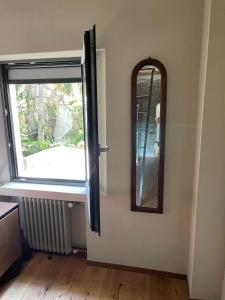 a mirror next to a door with a window at Casa Gastone in Rimini
