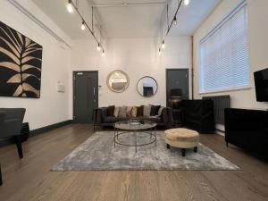un soggiorno con un divano e un tavolo di Cool warehouse conversion apt in Chiswick London a Londra