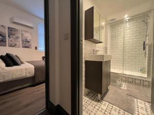 un bagno con lavandino e doccia e un letto di Cool warehouse conversion apt in Chiswick London a Londra