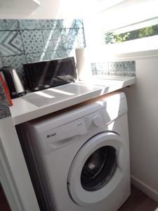 a laundry room with a washing machine under a counter at Studio indépendant location courte durée à proximité du Lycée International in Saint-Germain-en-Laye