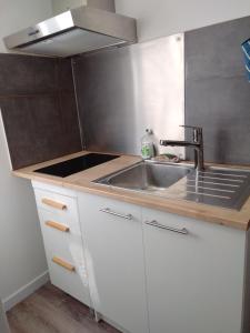 a small kitchen with a sink and a stove at Studio indépendant location courte durée à proximité du Lycée International in Saint-Germain-en-Laye +2 photos