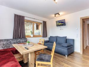 uma sala de estar com um sofá azul e uma mesa em Apartment Gletscherblick by Interhome em Zell am See