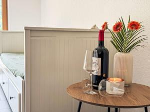 a table with a bottle of wine and two glasses at Apartment Urgen Living by Interhome in Fliess