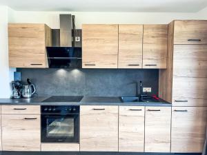 uma cozinha com armários de madeira e um fogão em Apartment Gletscherblick by Interhome em Zell am See