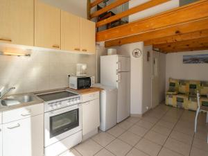 a kitchen with white appliances and wooden ceilings at Studio Nauzan by Interhome in Saint-Palais-sur-Mer +12 photos