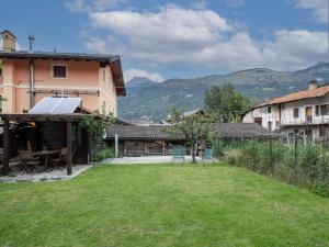 a yard with chairs and a house with mountains in the background at Holiday Home Le nid d'Alessandro by Interhome in Fenis