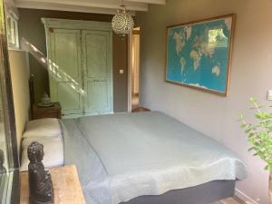1 dormitorio con 1 cama y un mapa en la pared en Het Zalige Buitenleven, en Lanaken