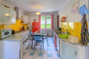 a kitchen with a red refrigerator and a table with chairs at Sixties Forever - une immersion années 60 in Aubenton +5 photos