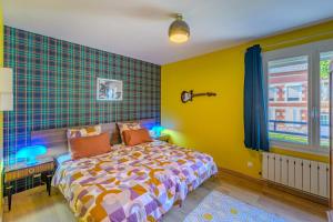 a bedroom with a bed and a yellow wall at Sixties Forever - une immersion années 60 in Aubenton