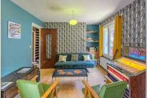 a living room with a couch and a tv at Sixties Forever - une immersion années 60 in Aubenton