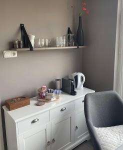 a white cabinet with a chair in a room at B&B de Notaris in Assen
