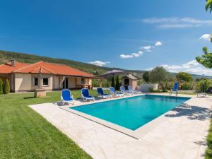 Una piscina con tumbonas y una casa. en Holiday Home Six Brothers by Interhome, en Donji Proložac
