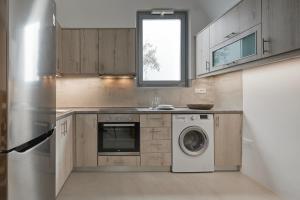 una cocina con nevera y lavadora en Imerovigli Iliovasilema Villa, en Imerovigli